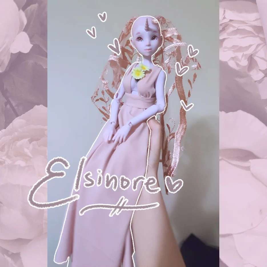 Elsinore without a wig, wearing a pink dress and veil