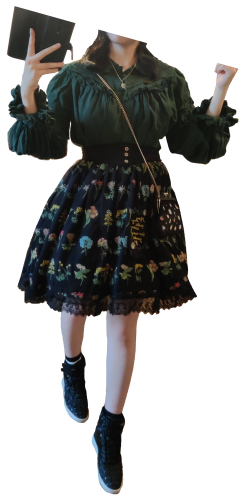 A casual lolita coord with a black skirt with flower embroidery and a green blouse